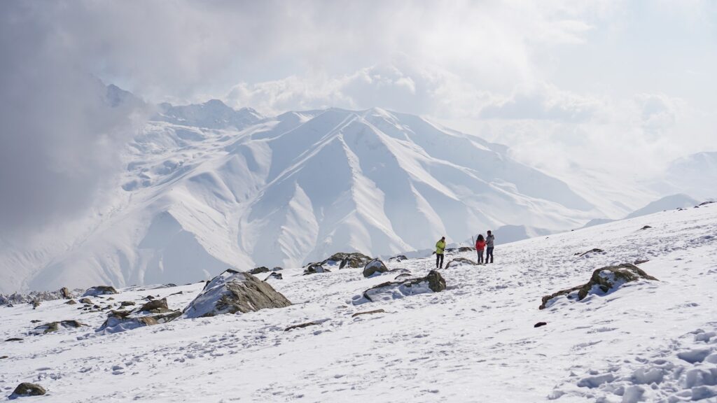 People Hiking on Snow Covered Mountain