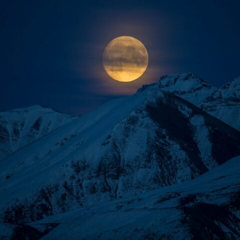 snow coated mountain at night time