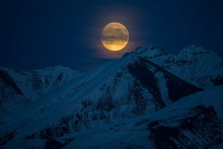 snow coated mountain at night time